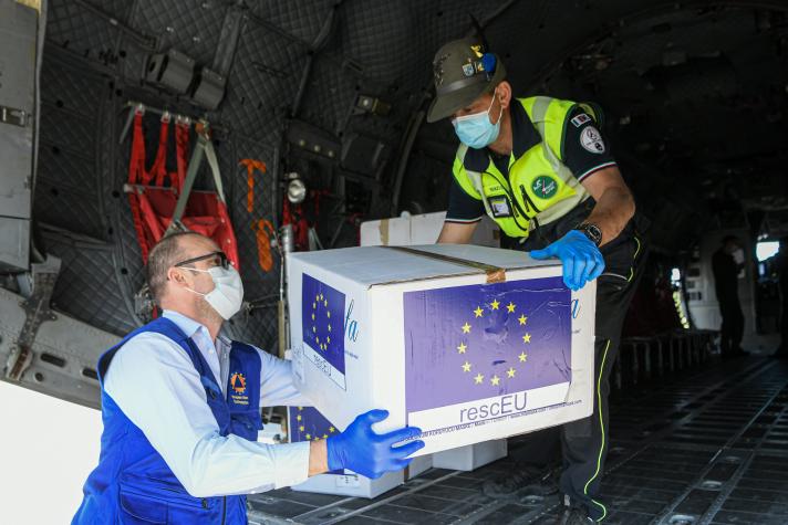 2 people handing over a box from a plane